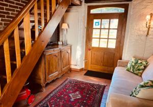 a living room with a staircase and a couch at La Grange de Jeanne in Moosch