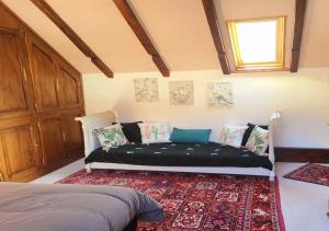 a bedroom with a bed with a rug and a window at La Grange de Jeanne in Moosch