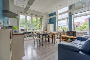 a kitchen and living room with a table and chairs at Flensbed Hotel & Hostel in Flensburg