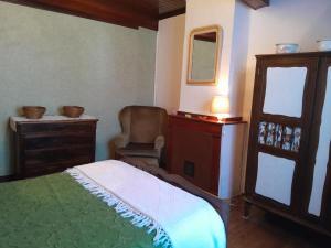 a bedroom with a bed and a chair and a mirror at Oustal marcellin in Fanjeaux