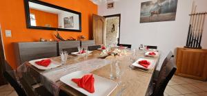 a dining room with a long table with red napkins at Gite L'évasion à Cheneux Stoumont in Stoumont