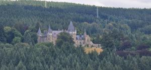 a castle on the side of a hill with trees at Gite L'évasion à Cheneux Stoumont in Stoumont