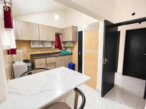 a kitchen with a white table and a black door at Nest at Imaara in Nairobi