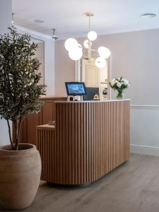 Una oficina con un escritorio con una computadora y una planta. en Hotel Cisneros, en Alcalá de Henares