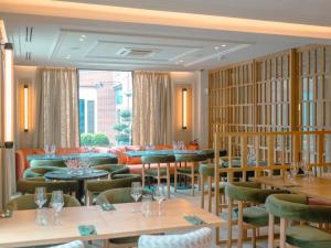 un restaurante con mesas y sillas en una habitación en Hotel Cisneros, en Alcalá de Henares