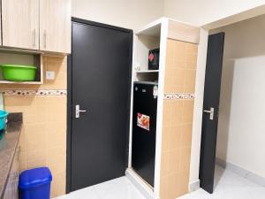 a kitchen with a black refrigerator in a room at Nest at Imaara in Nairobi +2 photos