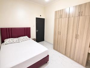 a bedroom with a large bed and wooden cabinets at Nest at Imaara in Nairobi