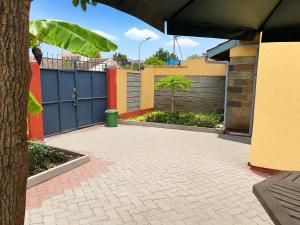 a driveway in front of a house with a fence at Nest at Imaara in Nairobi