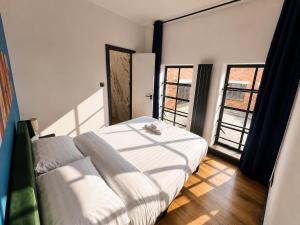 a bedroom with a bed and two large windows at 2BR Central Apt - Parking -2 Baths - Bars & Trains in Liverpool