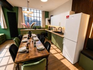 a kitchen with a long table with chairs and a refrigerator at 2BR Central Apt - Parking -2 Baths - Bars & Trains in Liverpool +11 photos