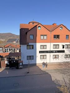 two people walking in front of a building at Schinkels Brauhotel in Witzenhausen