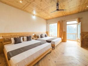 a bedroom with two beds and a large window at Silent Stone Homestay in Almora