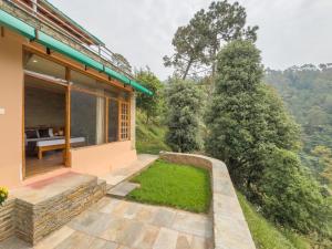 a view of a house with a patio and grass at Silent Stone Homestay in Almora