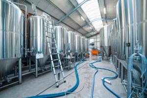 a brewery with a row ofbeer tanks in a building at Schinkels Brauhotel in Witzenhausen