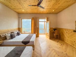 a bedroom with two beds and a large window at Silent Stone Homestay in Almora