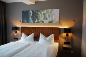 a bedroom with a bed with two white pillows at Schinkels Brauhotel in Witzenhausen