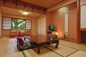 a living room with a table and a couch at Kotonoyado Musashino in Nara