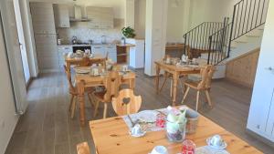 a kitchen and dining room with wooden tables and chairs at Strada Facendo in Collebrincioni