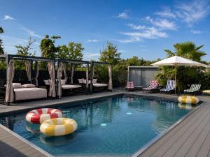 a swimming pool with balls and chairs and an umbrella at Baco Da Seta Residence con Piscina - Venezia Mestre in Mestre