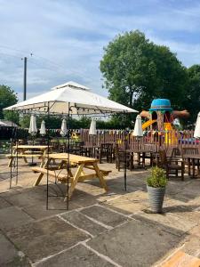 a playground with wooden tables and a play equipment at The Bickerton Poacher in Higher Burwardsley