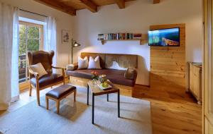 a living room with a couch and a chair at Köllhof in Höslwang