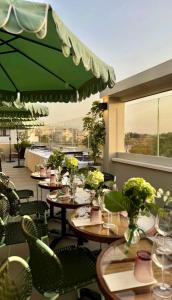 a restaurant with tables and chairs and a green umbrella at Didimos Town Hotel in Reggio di Calabria