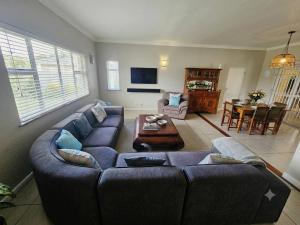 a living room with a couch and a table at Three on Firmount in Somerset West