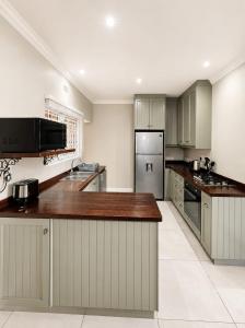 a kitchen with stainless steel appliances and wooden counter tops at Three on Firmount in Somerset West