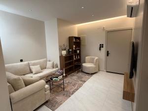 a living room with a couch and a chair at شقة مودرن غرفة وصالة in Buraydah