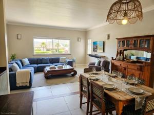 a living room with a table and a blue couch at Three on Firmount in Somerset West
