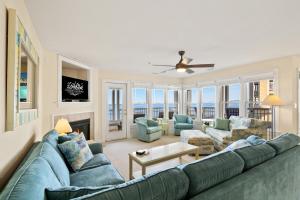 a living room with a blue couch and chairs at BCBPV1411 Ballast Point in Manteo