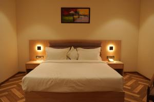 a bedroom with a large bed with two night stands at Hotel Tavijay in Jhunjhunūn