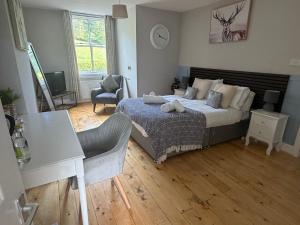 a bedroom with a bed and a table and a chair at The Bickerton Poacher in Higher Burwardsley