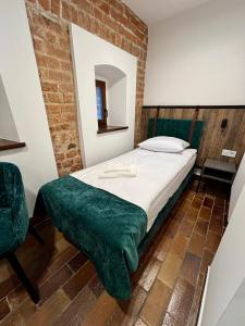 a bedroom with a bed with a green blanket on it at Hotel&Restauracja Zamek Bytów in Bytów