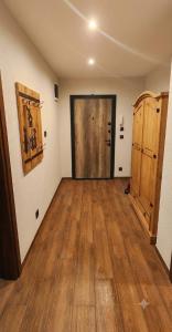 an empty room with a large door and wooden floors at Rhodopski Apartment in Chepelare