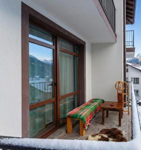 a balcony with a bench and a table and a window at Rhodopski Apartment in Chepelare