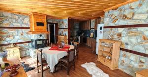 a dining room with a table and a stone wall at Rhodopski Apartment in Chepelare +1 photo