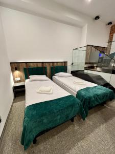 a room with two beds with green sheets at Hotel&Restauracja Zamek Bytów in Bytów