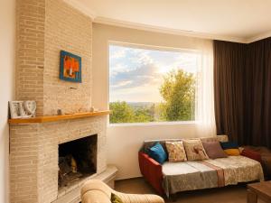 a living room with a fireplace and a window at Kibula Horizon in Ureki