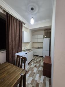 a kitchen with a table and a kitchen with a refrigerator at At home in Yerevan +8 photos