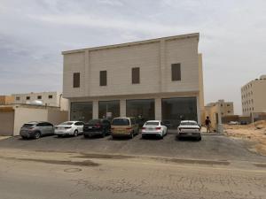 a parking lot with cars parked in front of a building at شقة مودرن غرفة وصالة in Buraydah
