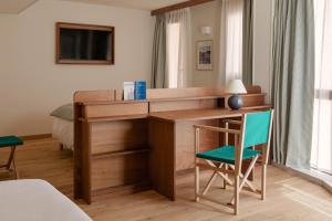 a desk in a room with a green chair at Alfred Hotels Toulouse Victor Hugo - Hôtel Rénové in Toulouse