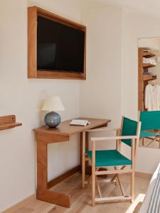 a room with a desk with a television and chairs at Alfred Hotels Toulouse Victor Hugo - Hôtel Rénové in Toulouse