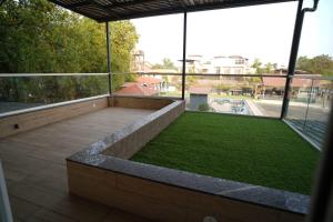 a large patio with a grassy area on a building at The Tree Resort in Malavli