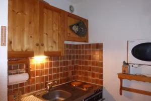 a kitchen with a sink and a microwave at Studio with mountain view in Barcelonnette in Barcelonnette