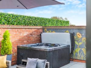 a hot tub sitting next to a brick wall at Foreman's Cottage in Skidby