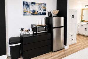a kitchen with a refrigerator and a counter with a microwave at Legends Fountain View Ground Floor Studio Unit 109 in Bellaire