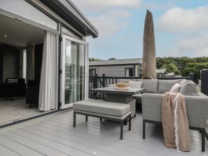 a patio with a table and chairs on a deck at Lakewood Plot 2 in Clacton-on-Sea