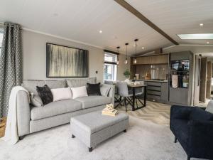 a living room with a couch and a kitchen at Lakewood Plot 2 in Clacton-on-Sea