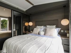 a bedroom with a large bed and two lamps at Lakewood Plot 2 in Clacton-on-Sea